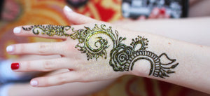 Henna design on hand with gold glitter